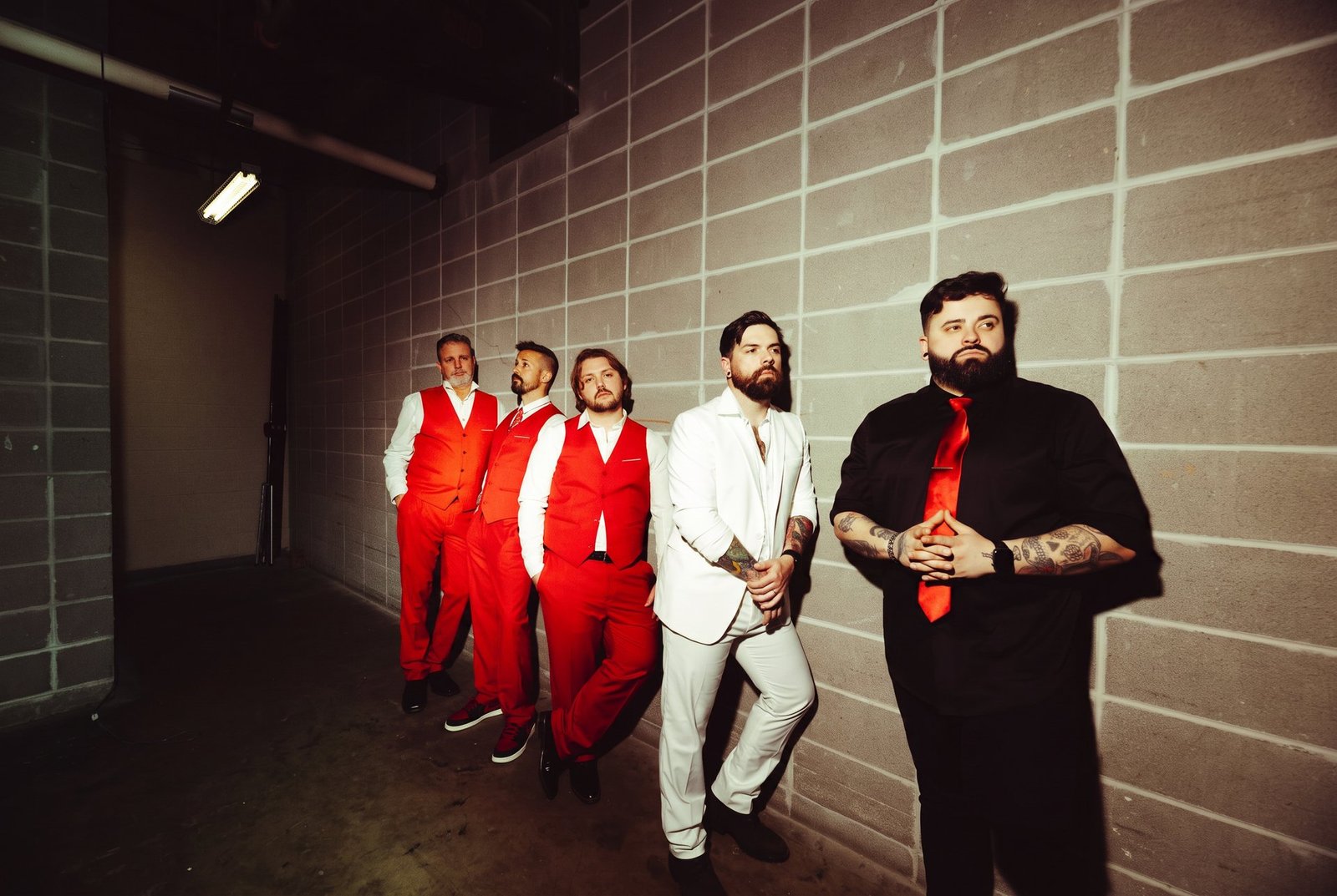 Count The Years promo shot in red suits against a cinder block wall